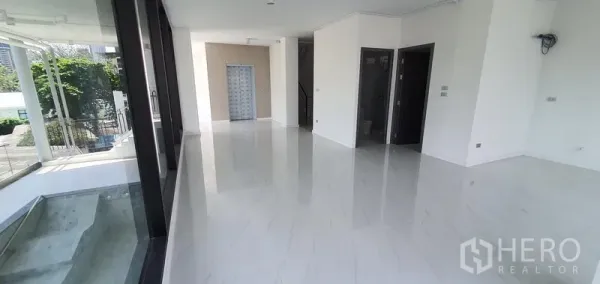 带办公室的家 出租或出售在Watthana, Bangkok - 一楼大堂或展厅，白色亮面大理石地面与整面玻璃墙。