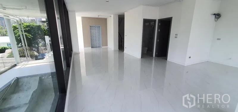 带办公室的家 出租或出售在Watthana, Bangkok - 一楼大堂或展厅，白色亮面大理石地面与整面玻璃墙。