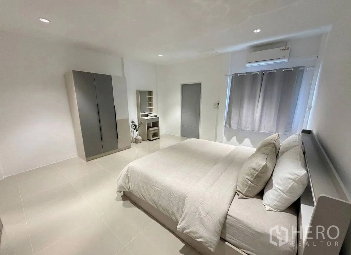 ทาวน์เฮาส์ for rent in Phra Khanong, Bangkok - ห้องนอนหลักกว้าง เตียงคู่ ตู้เสื้อผ้า โต๊ะเครื่องแป้ง และเครื่องปรับอากาศ.