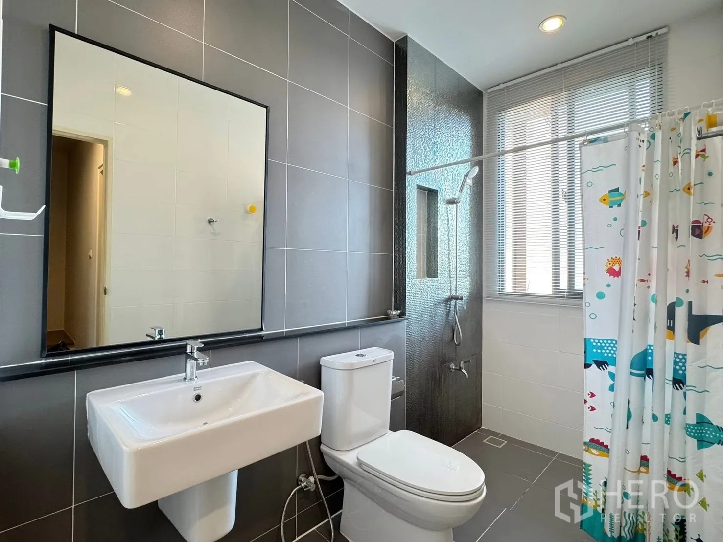 Townhouse for rent in Saphan Sung, Bangkok - Modern bathroom with gray tiles, shower zone and window blinds.
