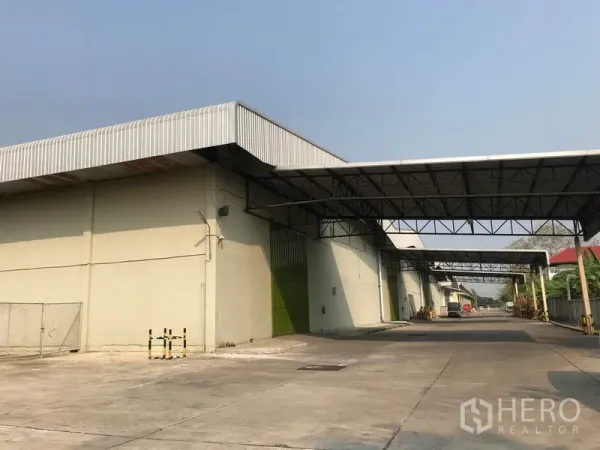Warehouse for rent in Bang Pa-in, Phra Nakhon Si Ayutthaya - Front façade of warehouse featuring multiple green roll-up doors, canopy links, and straight truck access lane.