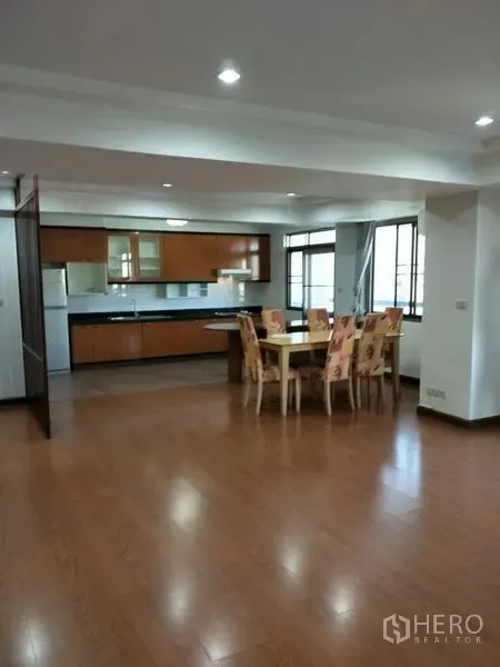 公寓 出租在Watthana, Bangkok - 宽敞的客餐厅，嵌灯照明，六人餐桌，旁连开放式厨房与大窗户。