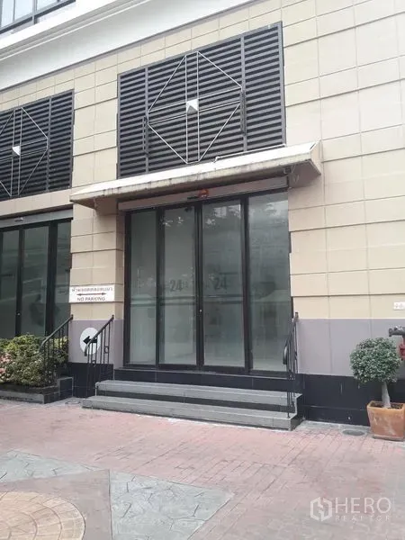 Retail Space for rent in Watthana, Bangkok - Street-level retail storefront with glass double doors, steps, and awning in a modern building.
