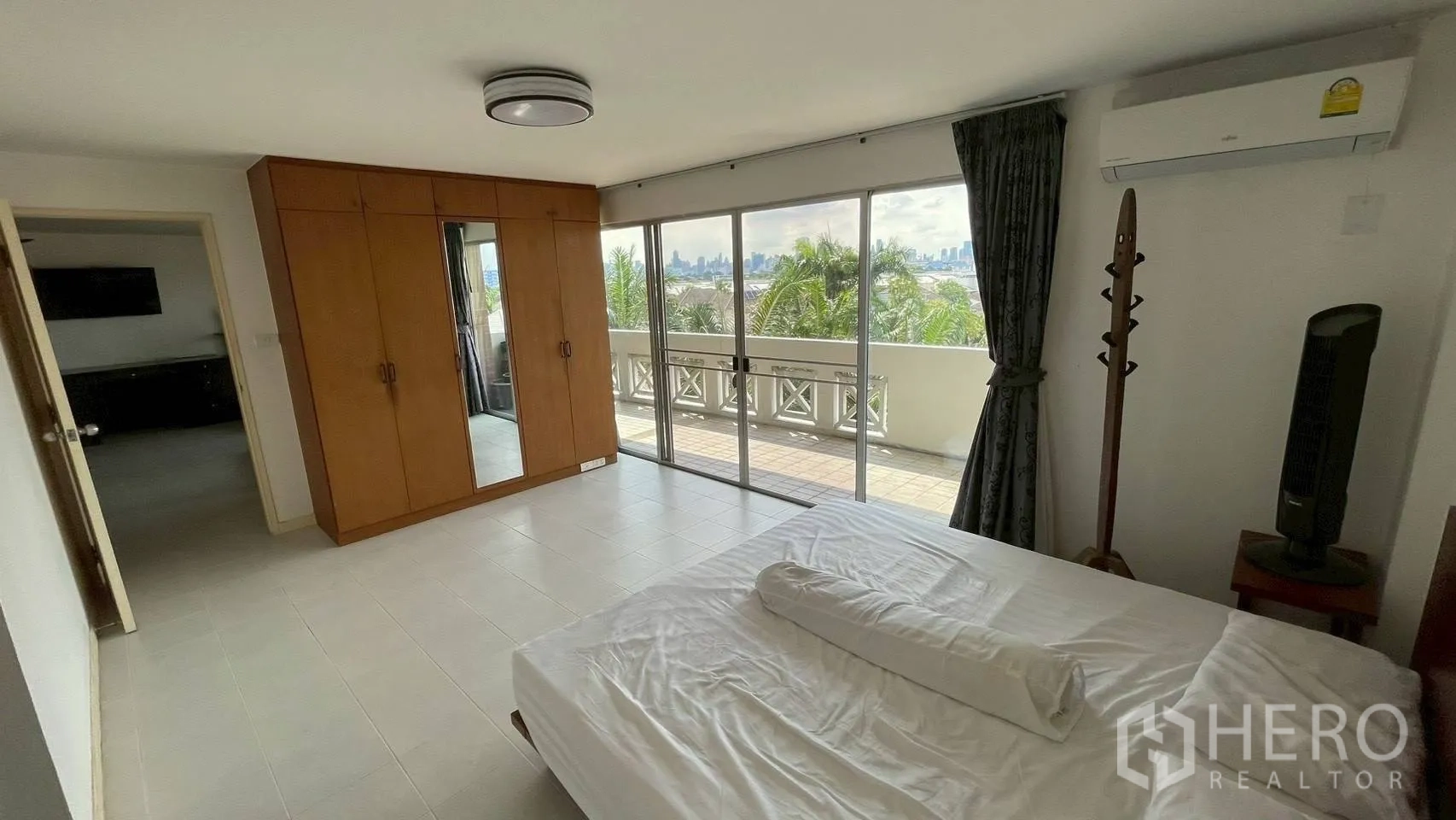 Condominium for sale in Wang Thonglang, Bangkok - Master bedroom with built-in wardrobe and wide sliding glass to the balcony.