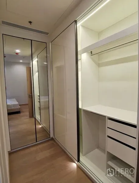 Condominium for rent in Bang Rak, Bangkok - Fitted dressing area featuring sliding mirrored wardrobes, open shelves and drawers.