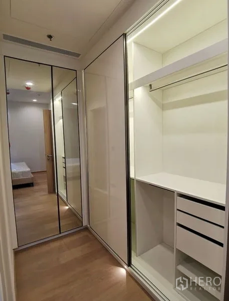 Condominium for rent in Bang Rak, Bangkok - Fitted dressing area featuring sliding mirrored wardrobes, open shelves and drawers.