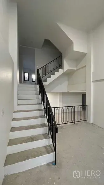 Townhouse for sale in Prawet, Bangkok - Staircase with black metal railing connecting multiple levels.