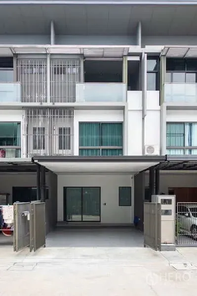 ทาวน์เฮาส์ ให้เช่าหรือขายในLat Phrao, Bangkok - ด้านหน้าอาคารทาวน์โฮม 3 ชั้น สมัยใหม่ มีระเบียงและประตูรั้วทางเข้า