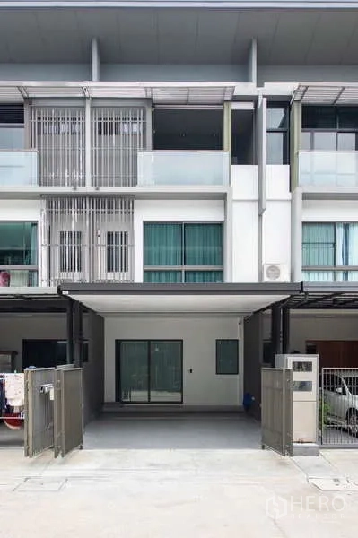 ทาวน์เฮาส์ ให้เช่าหรือขายในLat Phrao, Bangkok - ด้านหน้าอาคารทาวน์โฮม 3 ชั้น สมัยใหม่ มีระเบียงและประตูรั้วทางเข้า