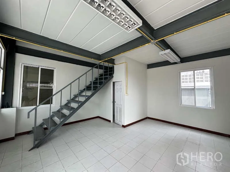 Warehouse for rent in Pak Kret, Nonthaburi - Tiled mezzanine office with metal staircase and ceiling lights inside the warehouse.