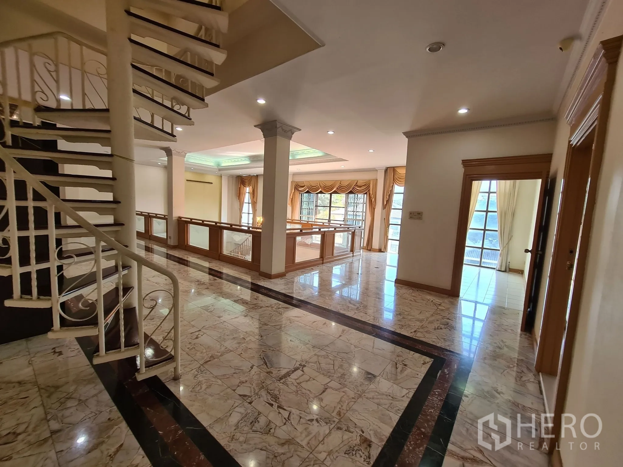 Detached House for sale in Chatuchak, Bangkok - Spiral staircase and open mezzanine with decorative ceiling lighting.