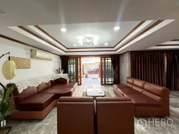 สำนักงานที่บ้าน ให้เช่าในWatthana, Bangkok - ห้องนั่งเล่นกว้าง โซฟาหนังสีน้ำตาล ฝ้าเล่นระดับและไฟดาวน์ไลท์