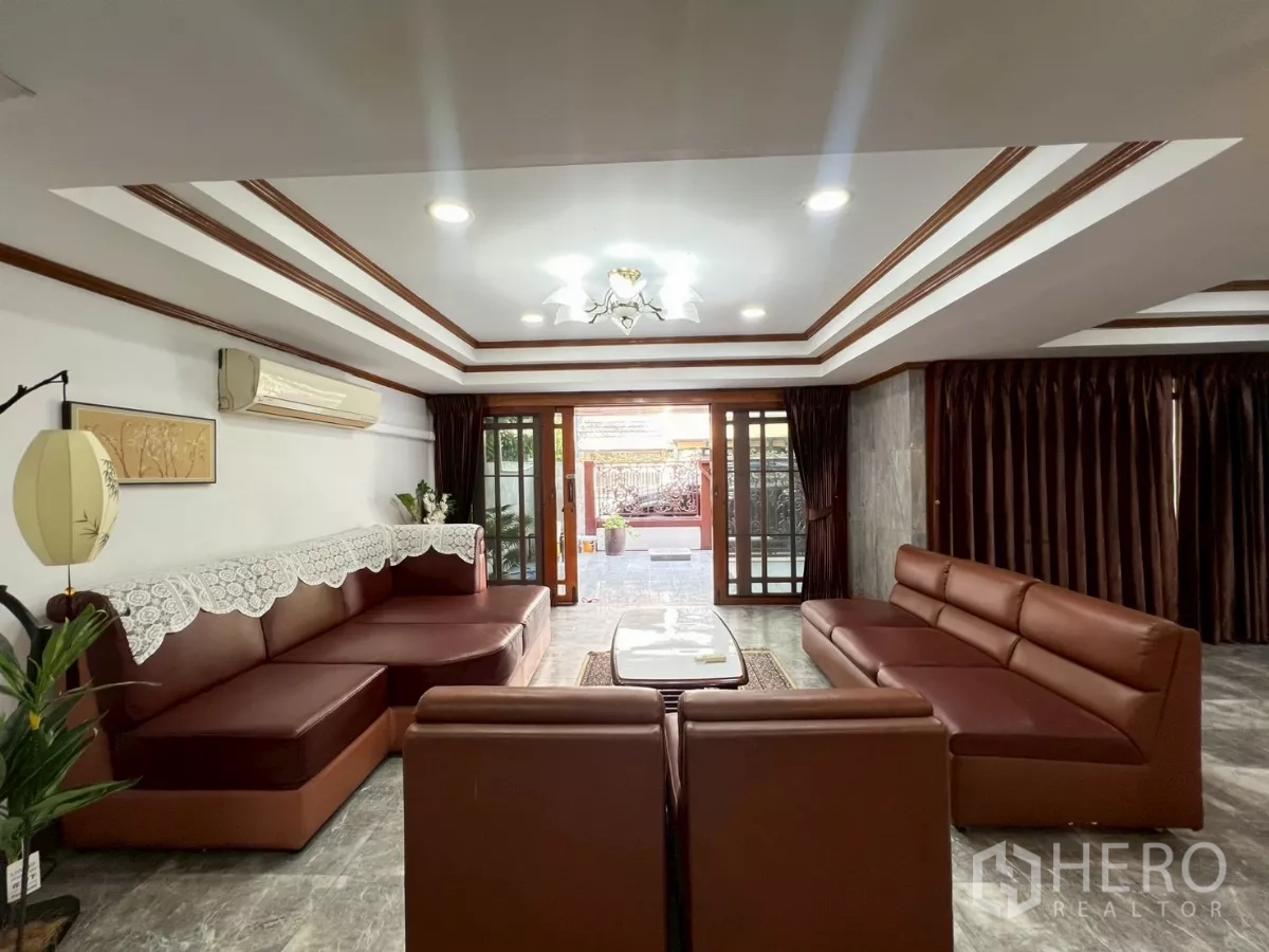 สำนักงานที่บ้าน ให้เช่าในWatthana, Bangkok - ห้องนั่งเล่นกว้าง โซฟาหนังสีน้ำตาล ฝ้าเล่นระดับและไฟดาวน์ไลท์