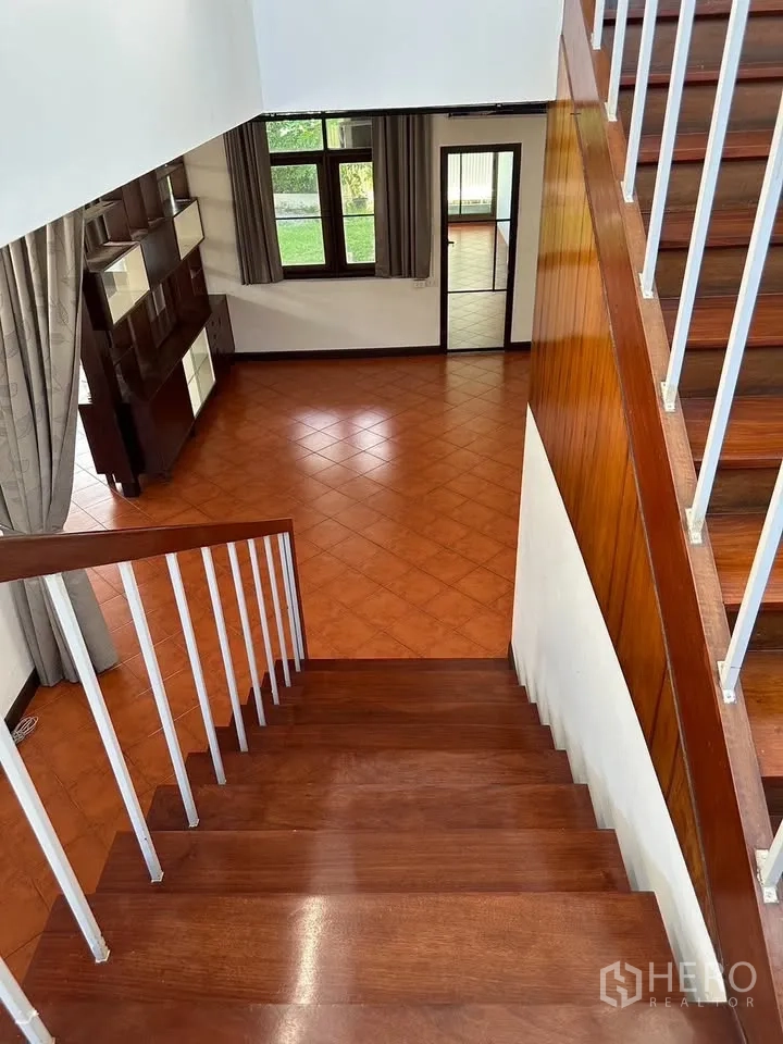 Detached House for rent in Phra Khanong, Bangkok - View from wooden staircase over open-plan living area with garden outlook.