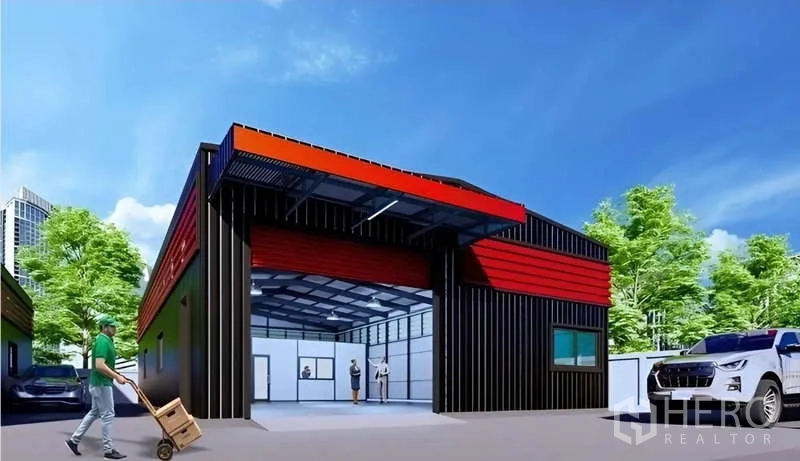 Warehouse for rent in Lat Phrao, Bangkok - Modern black-and-red warehouse exterior in Lat Phrao with a wide roller shutter, driveway, and on-site parking amid trees.