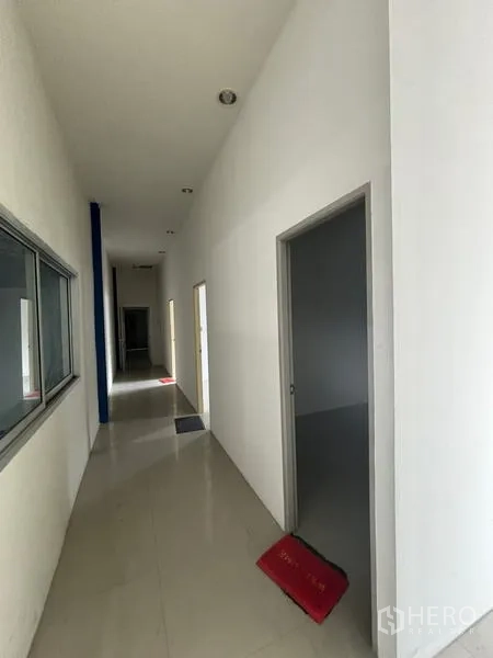 Warehouse for rent in Krathum Baen, Samut Sakhon - Long internal corridor with multiple office doors and an interior viewing window.