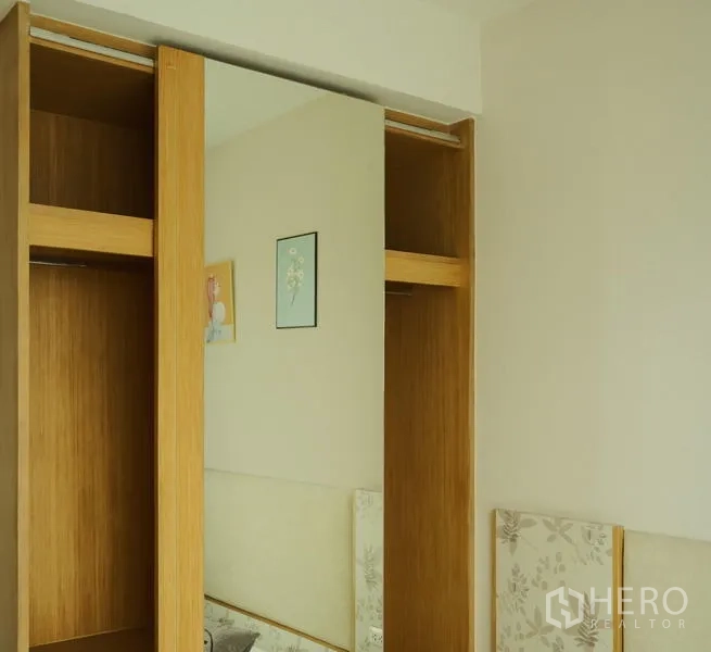 Condominium for rent in Bang Rak, Bangkok - Sliding wardrobe with mirrored door in a bright bedroom.