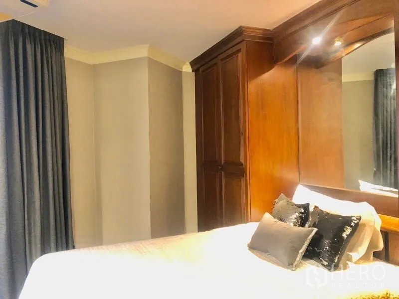 Condominium for rent in Watthana, Bangkok - Cozy bedroom with wooden wardrobes, mirrored headboard and heavy drapes