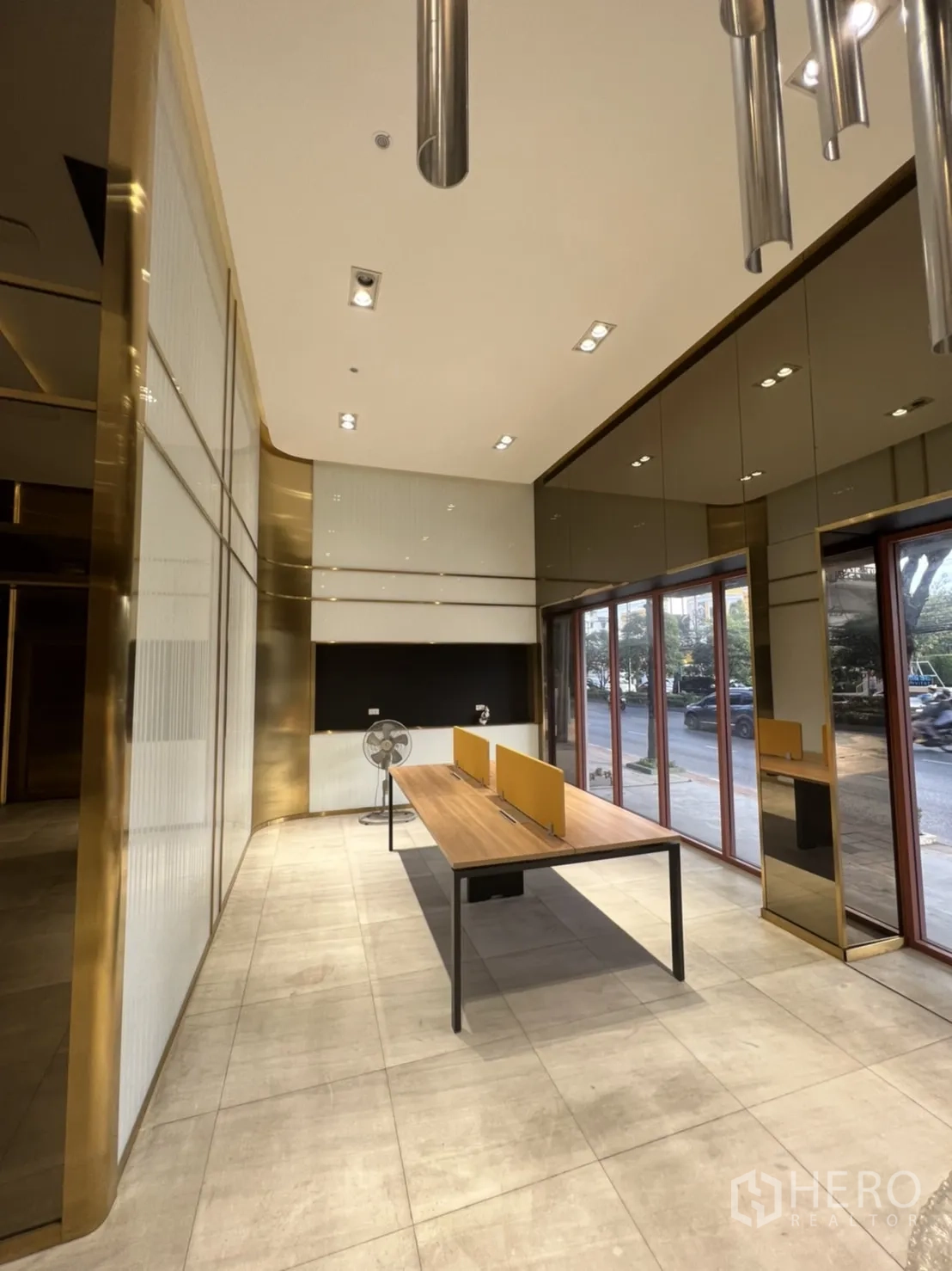 店屋 出租在Phra Khanong, Bangkok - 临街一层零售区，落地窗、瓷砖地面与长工作台，射灯明亮。