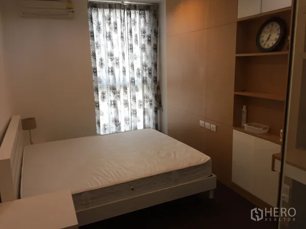 公寓 出租在Ratchathewi, Bangkok - 舒适卧室，双人床、空调、内置衣柜与图案窗帘。