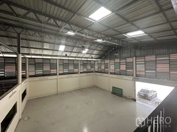 Warehouse for rent in Suan Luang, Bangkok - High-ceiling warehouse interior with steel trusses, skylights, and louvered ventilation panels.