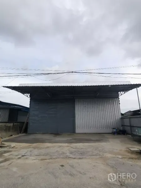 คลังสินค้า ให้เช่าในMin Buri, Bangkok - ด้านหน้าโกดังในเขตมีนบุรี ประตูเหล็กบานสไลด์พร้อมกันสาดลานขนถ่ายสินค้า