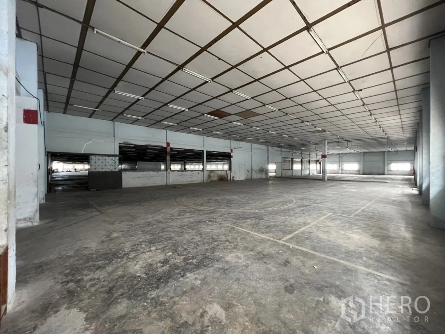 Factory for rent in Phra Samut Chedi, Samut Prakan - Secondary warehouse space with open layout, concrete floor and strip lighting.