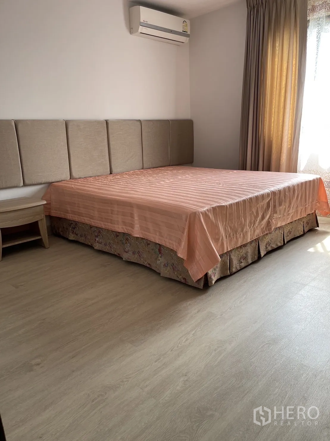 Condominium for rent or sale in Watthana, Bangkok - Bright master bedroom with padded headboard, air conditioner and light wood flooring.