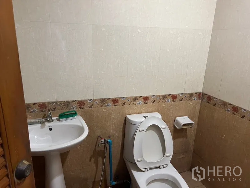 Retail Space for rent in Bang Rak, Bangkok - Private restroom with toilet, sink and tiled walls inside the retail unit.