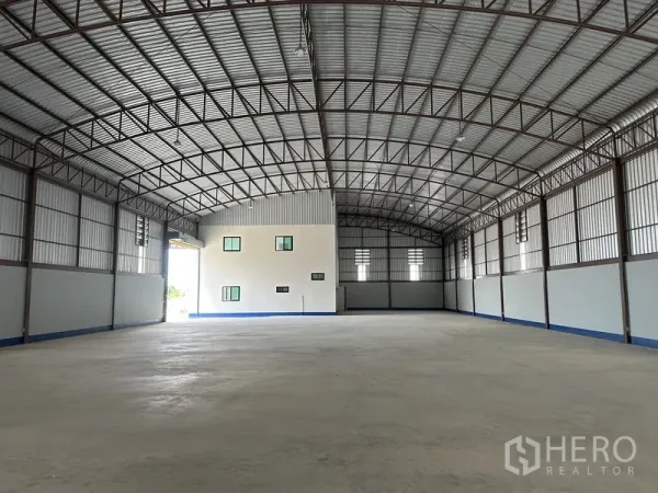Factory for rent or sale in Sai Noi, Nonthaburi - Spacious warehouse interior with arched steel roof, high clear height and polished concrete floor.