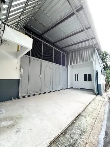 คลังสินค้า ให้เช่าในWang Thonglang, Bangkok - ทางเข้าโกดังพร้อมประตูเหล็กบานใหญ่และหลังคากันฝนในย่านวังทองหลาง กรุงเทพฯ