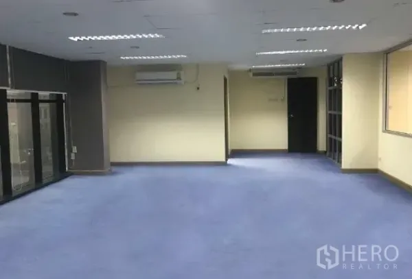 Office Space for rent in Bang Rak, Bangkok - Spacious open office with blue carpet, ceiling lights and air conditioning.