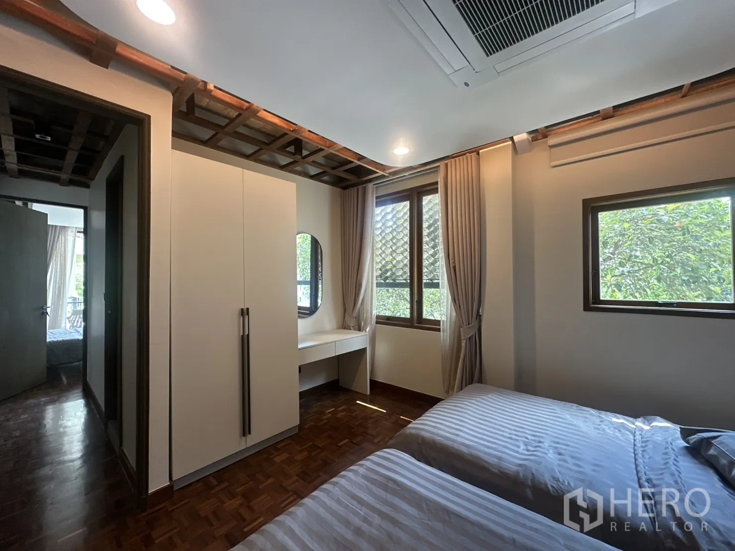 พื้นที่ขายของ for rent in Watthana, Bangkok - ห้องนอนเตียงคู่เห็นตู้เสื้อผ้า โต๊ะ และวิวต้นไม้สีเขียว.