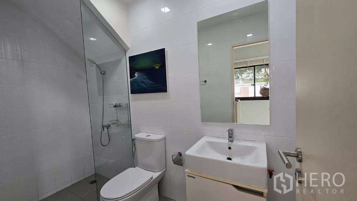 Townhouse for rent or sale in Saphan Sung, Bangkok - Ground-floor bathroom with glass shower enclosure, toilet and vanity.