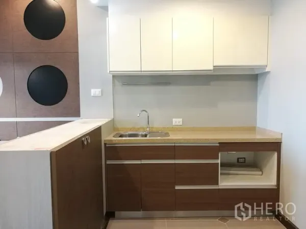 Condominium for rent in Sathon, Bangkok - Compact kitchenette featuring stone countertop, stainless-steel sink and upper and lower storage cabinets.