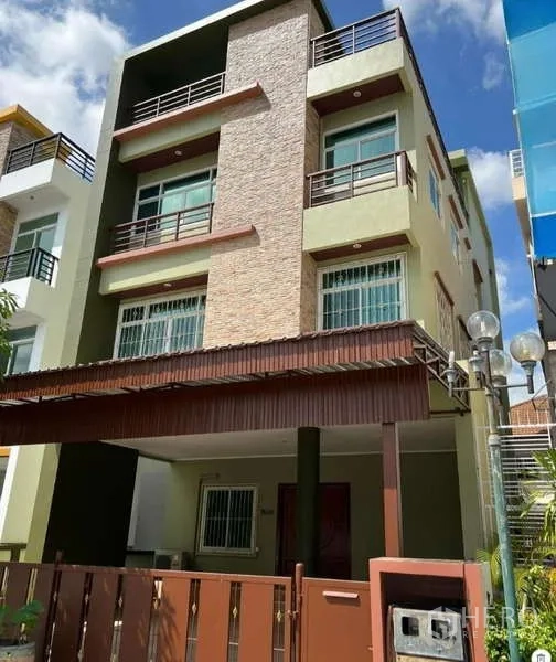 带办公室的家 出租或出售在Min Buri, Bangkok - 现代三层居家办公楼外观，设阳台、带顶车位与前院大门。
