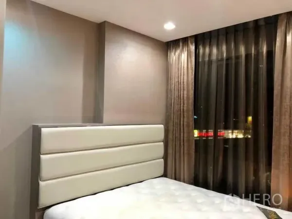 Condominium for rent or sale in Phaya Thai, Bangkok - Cozy bedroom with padded headboard and a large window with sheer drapes.