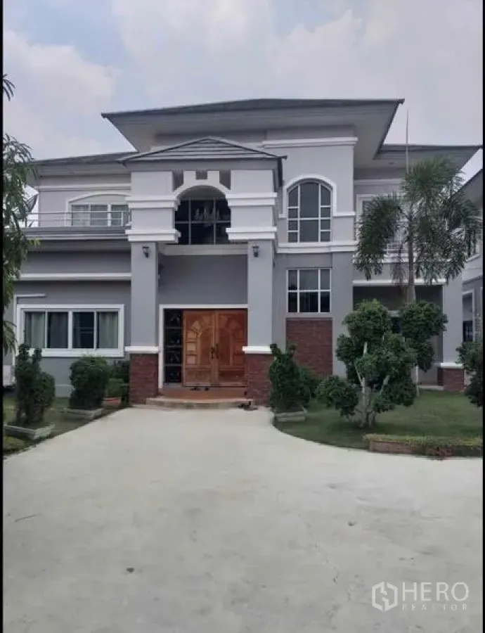 บ้าน ขายในLam Luk Ka, Pathum Thani - ด้านหน้าบ้านสองชั้นหลักพร้อมหน้าต่างโค้งและประตูไม้