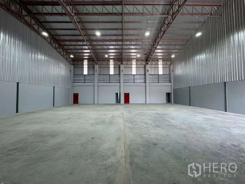 Warehouse for rent in Bang Phli, Samut Prakan - Warehouse interior view toward high wall windows and red doors