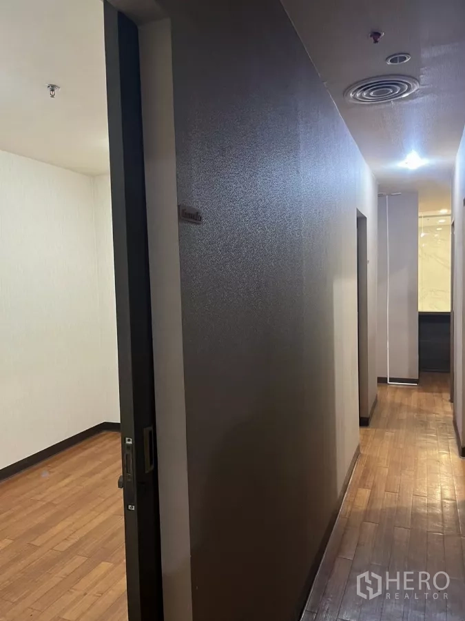Office Space for rent - Hallway with sliding doors leading to partitioned offices and wood flooring.