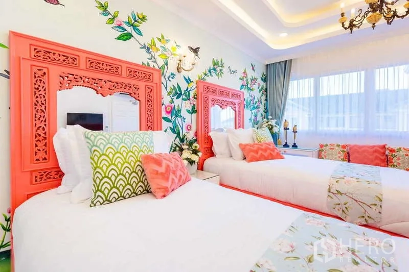 Townhouse for rent in Lat Phrao, Bangkok - Bright twin bedroom with floral mural, coral headboards and large windows with sheer curtains.