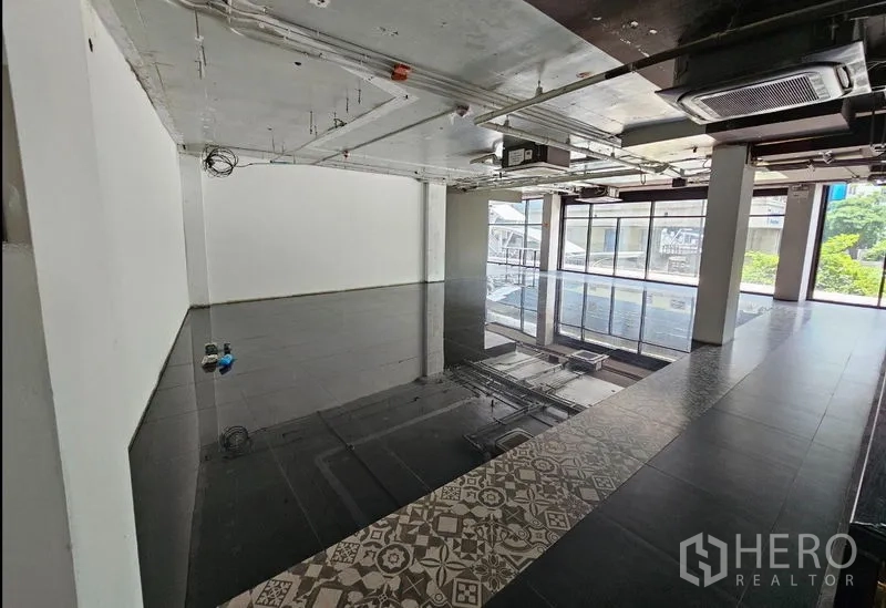 Retail Space for rent in Bang Rak, Bangkok - Corner retail unit with glass frontage, ducted air-conditioning on an exposed ceiling, and abundant natural light.