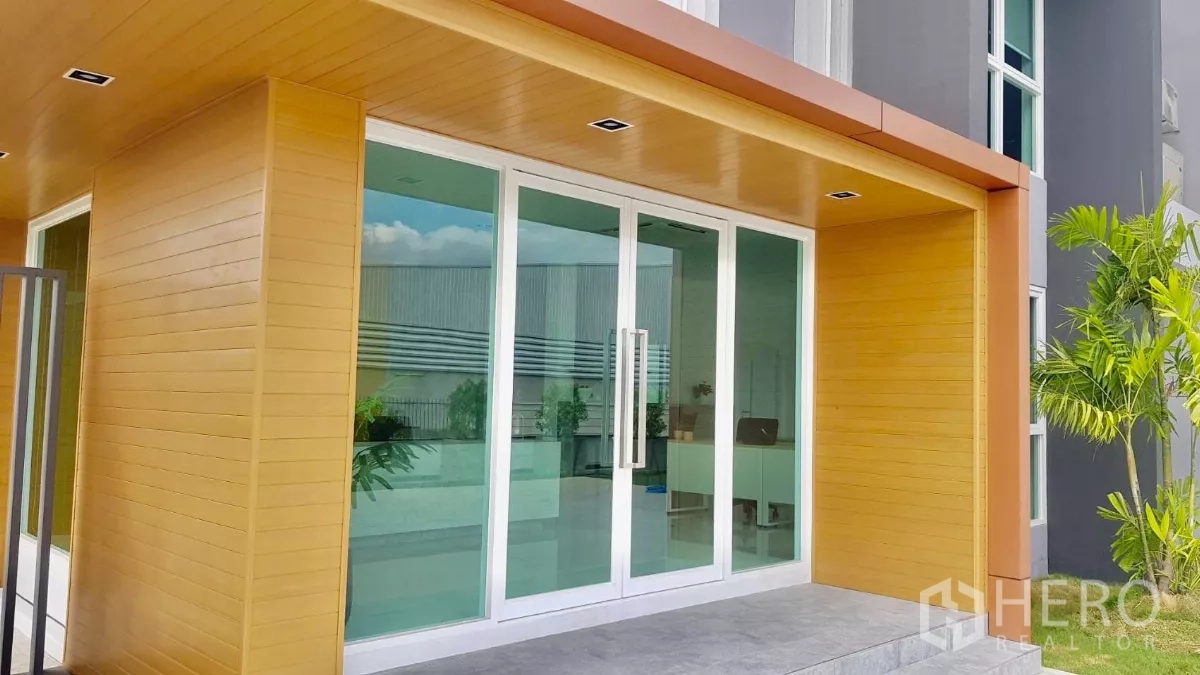 货栈 出售在Lam Luk Ka, Pathum Thani - 主入口玻璃推拉门，木色雨棚下。