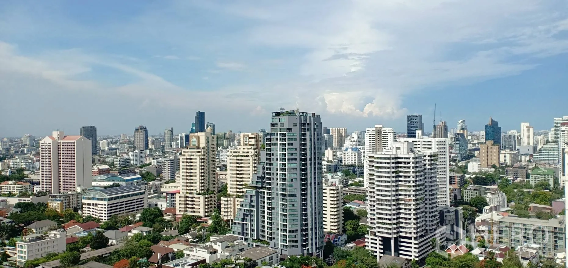 Condominium for rent in Watthana, Bangkok - High-floor city skyline view over Sukhumvit with modern towers and blue sky.
