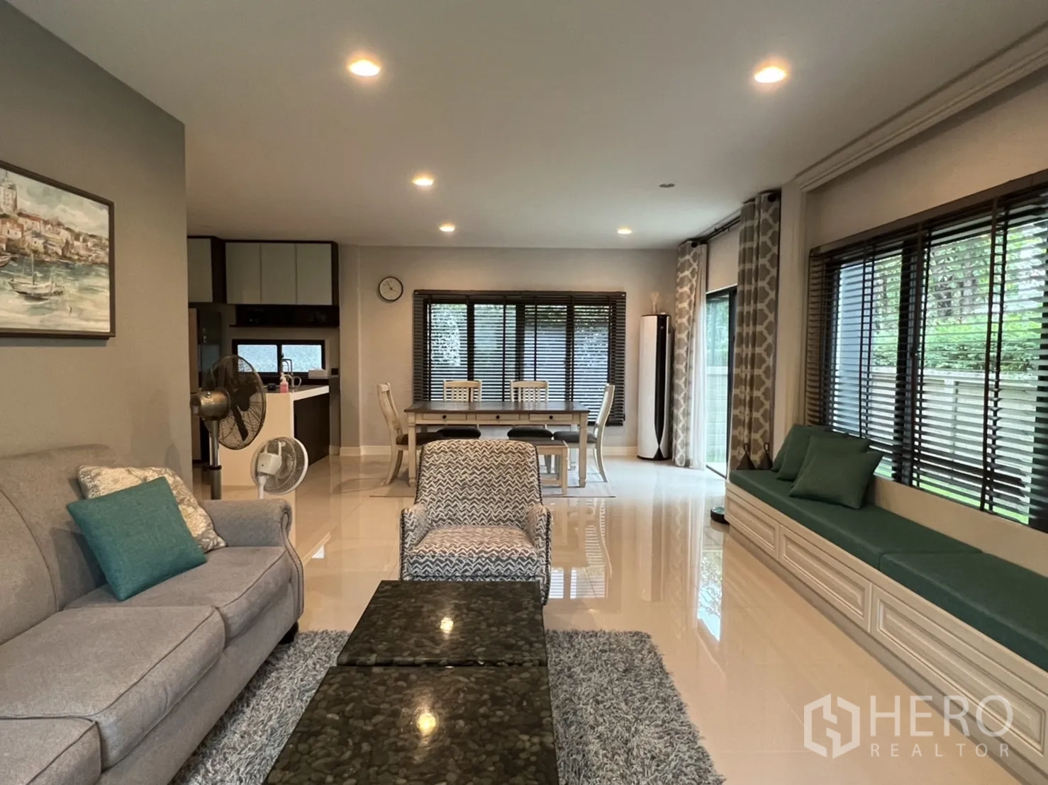 Detached House for rent or sale in Bang Kapi, Bangkok - Bright open-plan living and dining room with sofa set, built-in window bench and large windows.