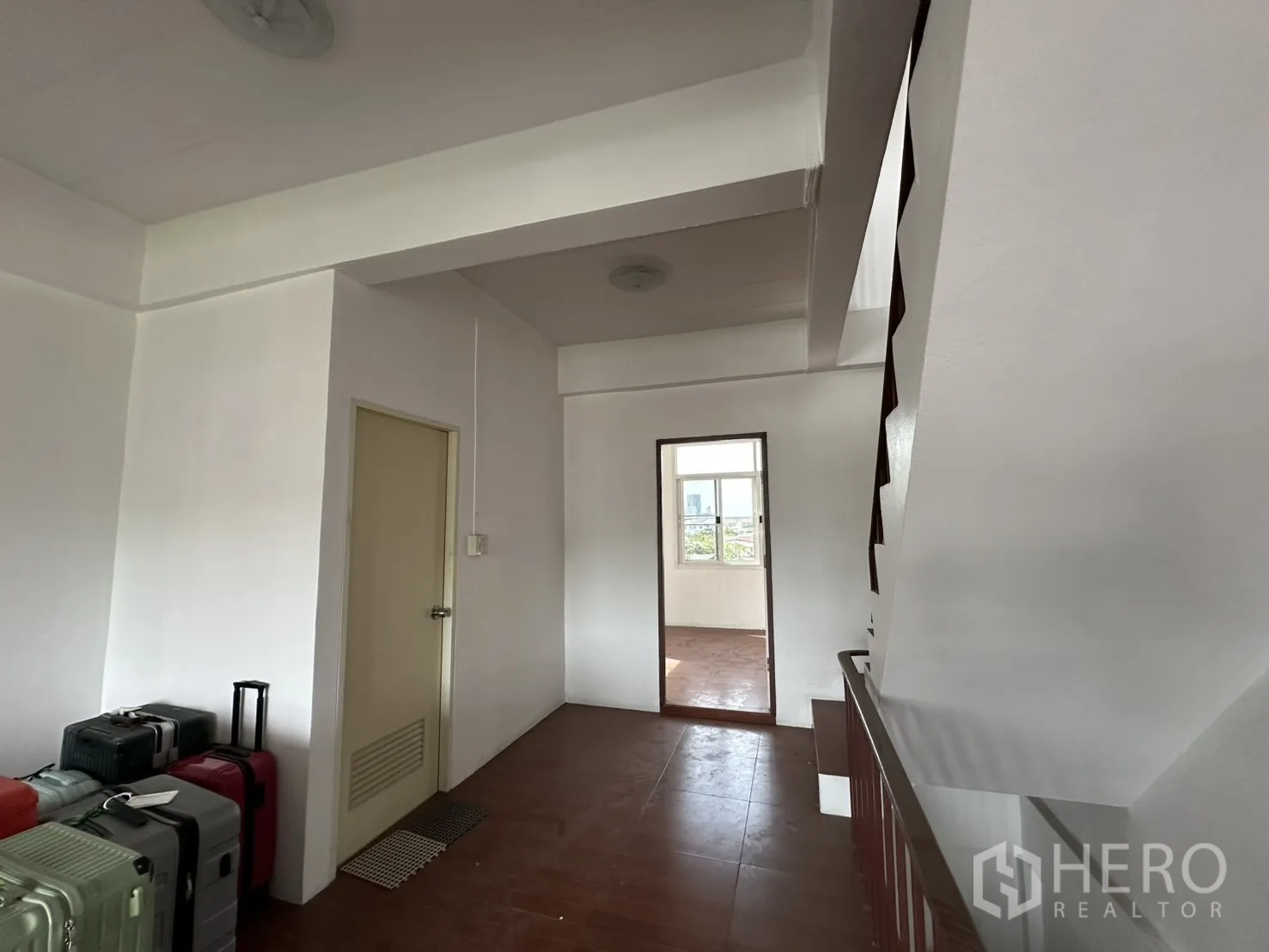 Shophouse for rent in Phra Khanong, Bangkok - Landing area with luggage and doorway to another room.