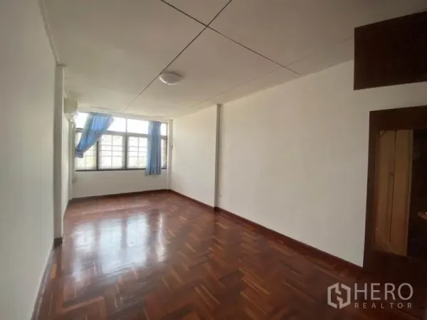 联排别墅 出租在Watthana, Bangkok - 采光充足的卧室，大窗与蓝色窗帘，木地板。