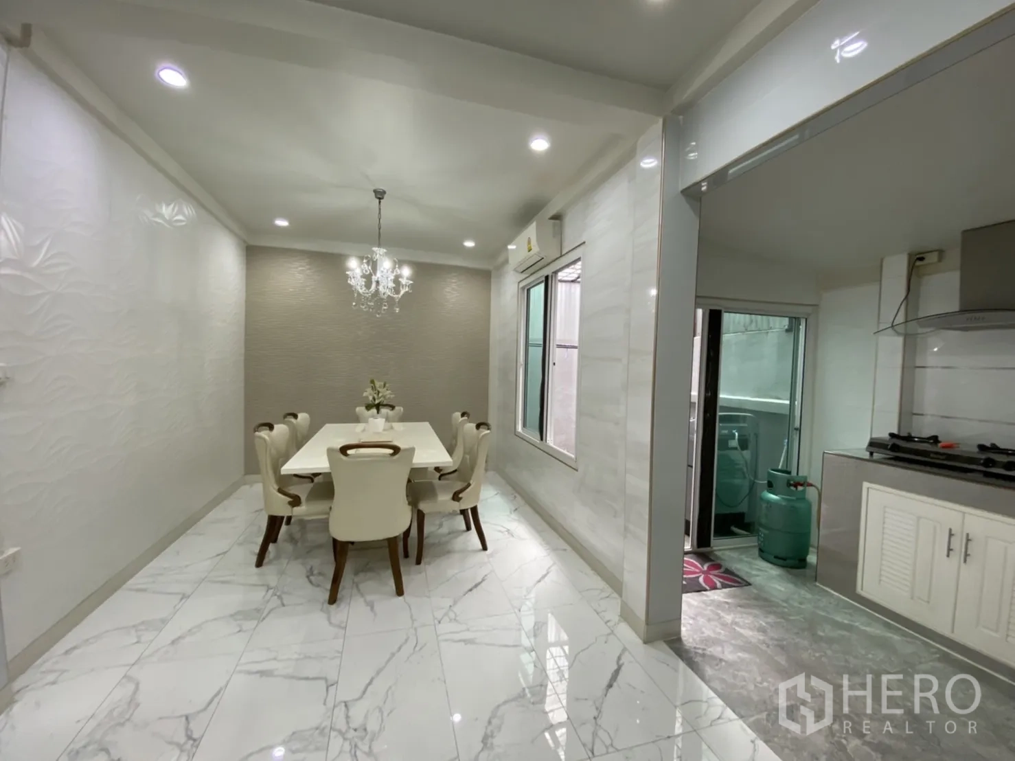 Townhouse for rent or sale - Bright dining area with chandelier and marble-look tiles beside the kitchen.