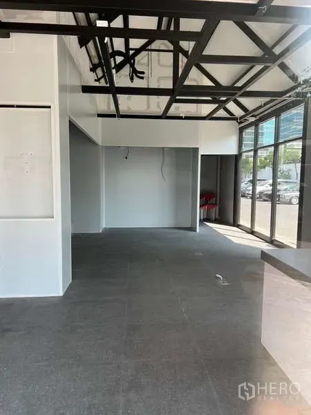 零售空间 出租 - 开放式室内，高挑空间，黑色钢梁与落地窗采光充足。