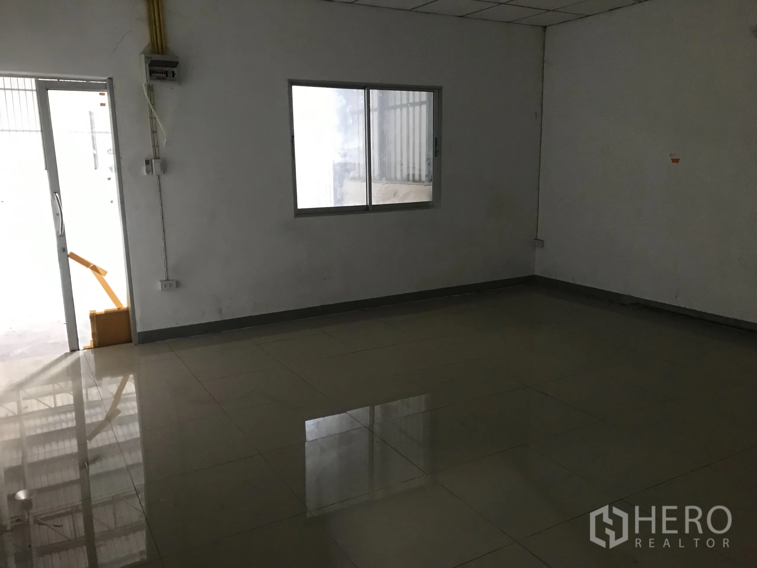 Warehouse for rent in Mueang Samut Prakan, Samut Prakan - Alternate angle of the tiled office room with windows overlooking the warehouse floor.